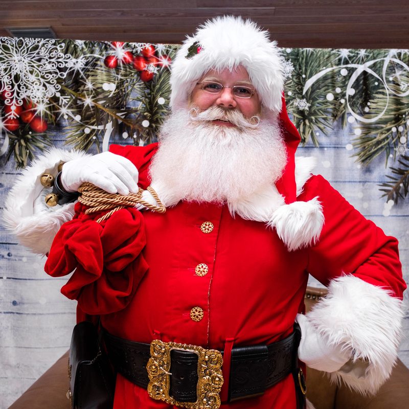 Santa Claus with his sack over one shoulder, smiling.
